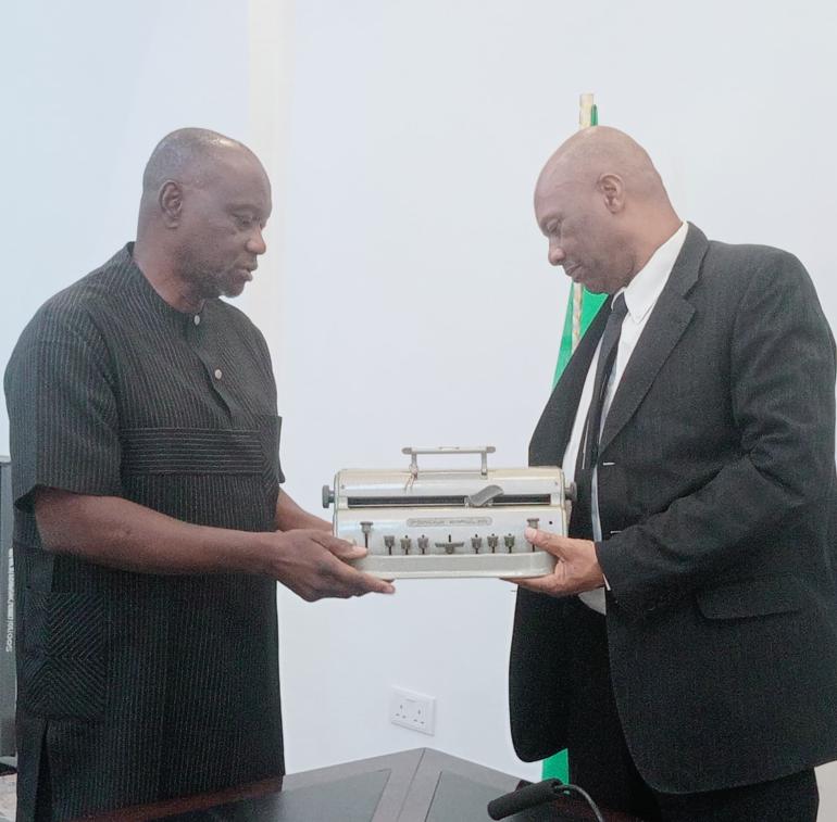 Mr. Andrew Gani-Ikilama, presenting two Perkins Braille Machines